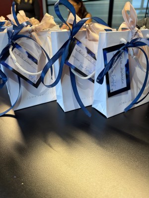White gift bags with blue ribbons, ready for the Everlast Group 25 years anniversary event.