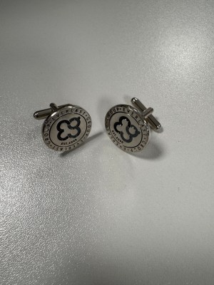 A pair of silver cufflinks celebrates 25 years with black and silver circular designs.