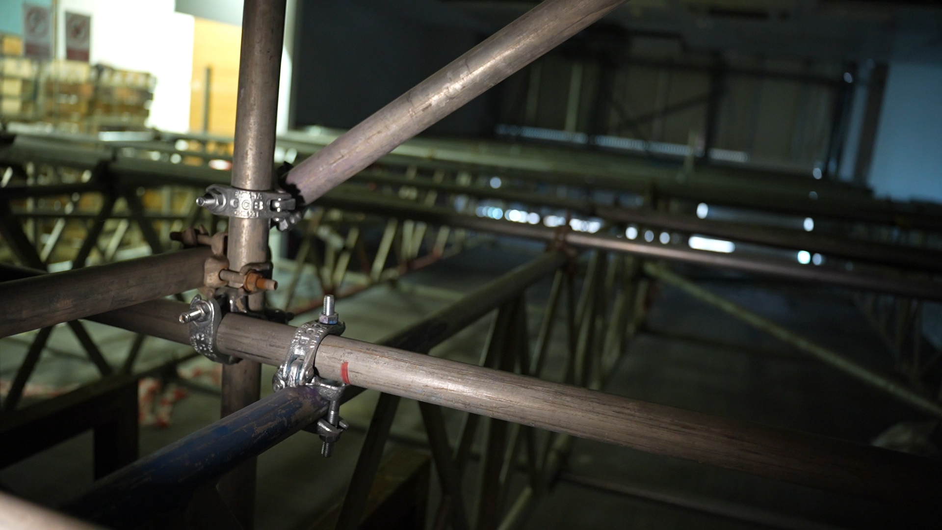 Metal scaffolding tubes and clamps form a structure inside Leeds' dimly lit City Exchange.