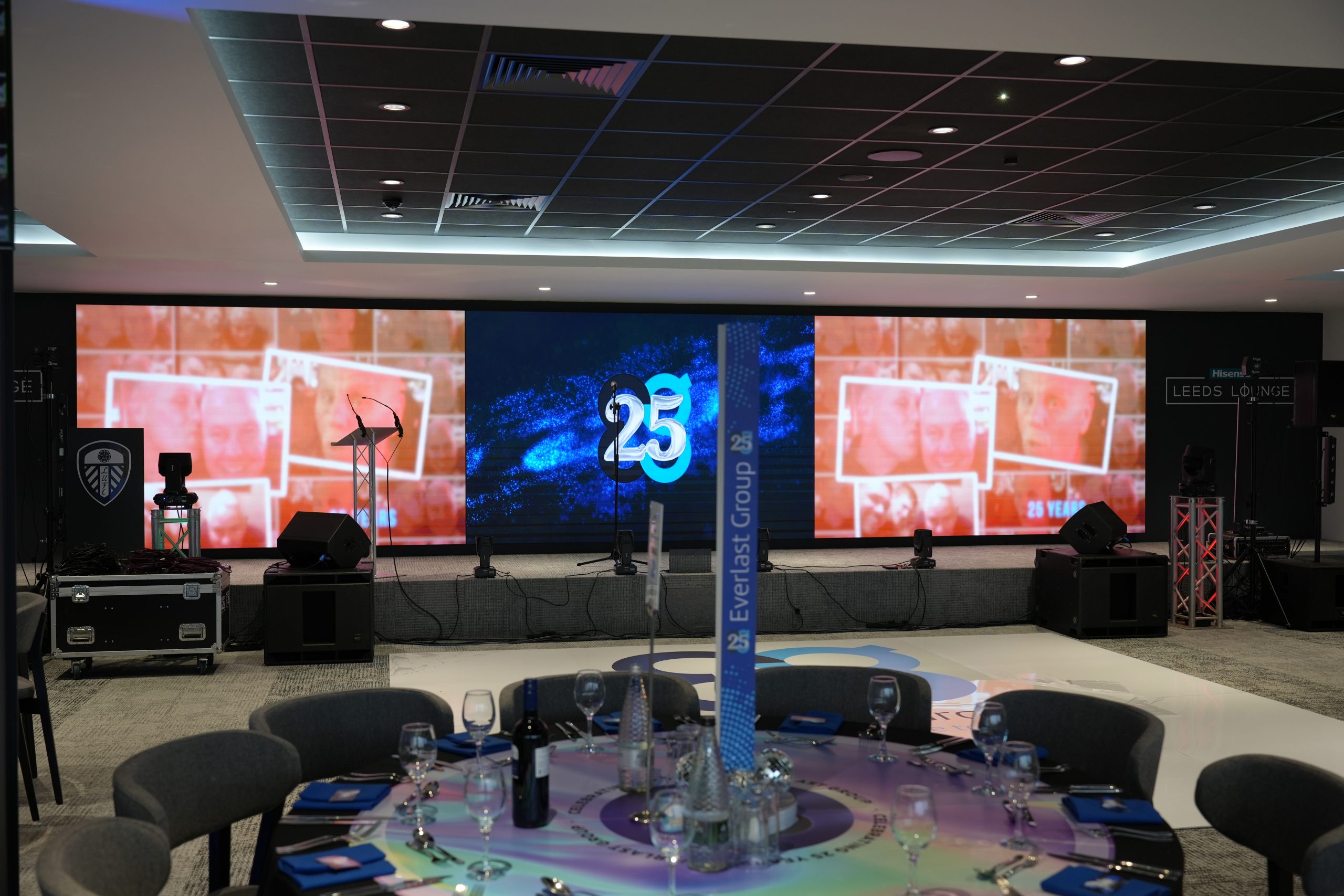 A decorated event stage at Elland Road with a “25 Years” sign and a round celebration table.