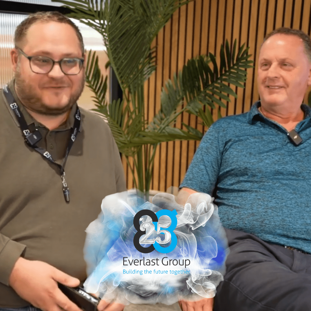 Two men smile as the Everlast Group 25th anniversary logo honours Richard Halkier.
