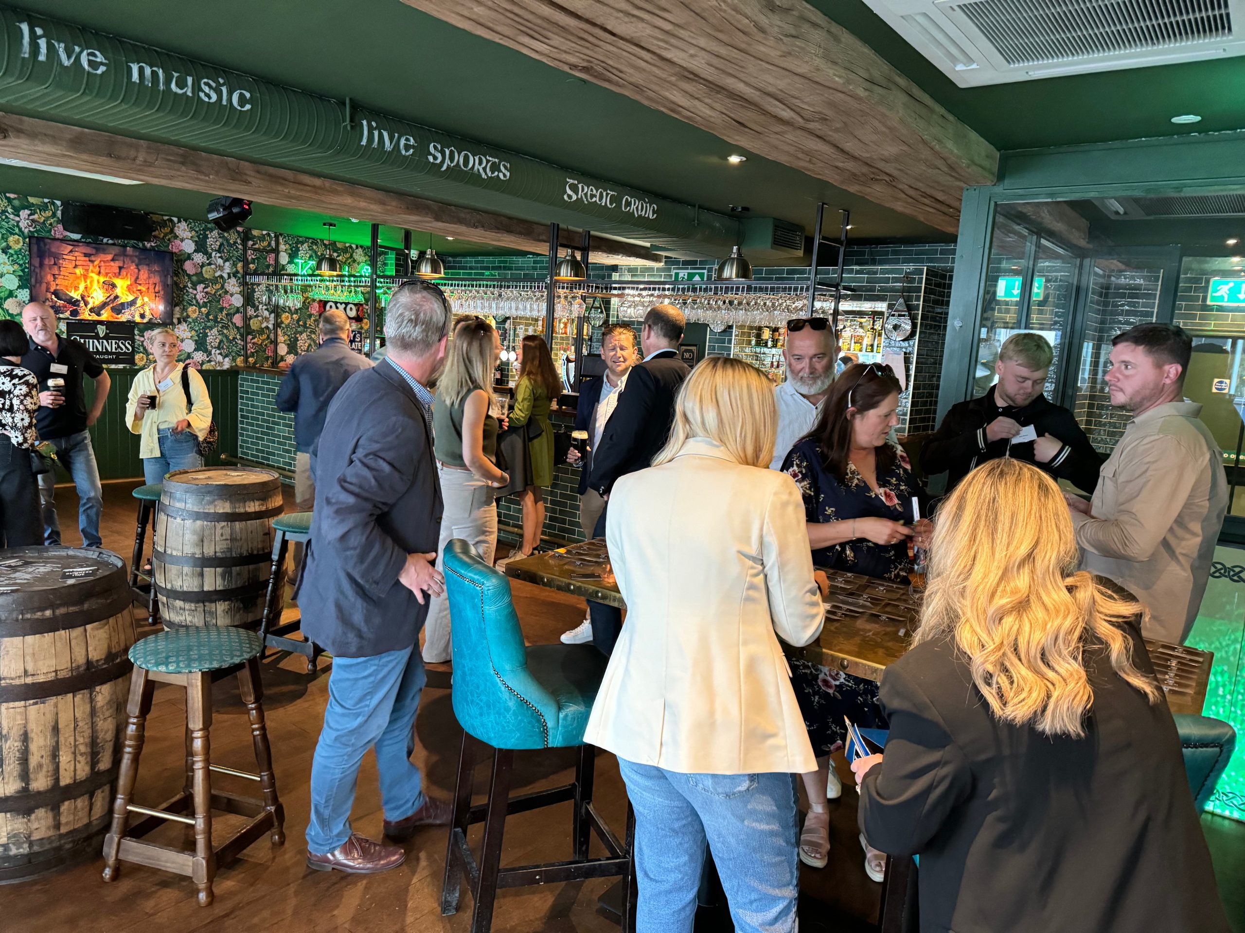 People socialising in a lively pub with wooden decor at a Construction networking Leeds event. Everlast Group Slainte and Stout Event May UKREiiF