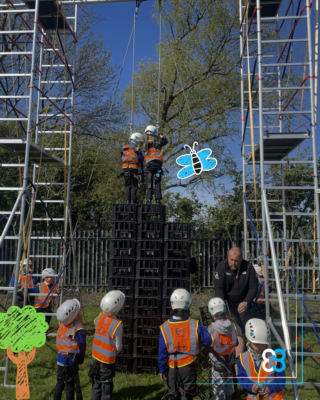 Children in helmets and vests stack crates, echoing a construction networking Leeds scene.
