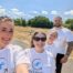 Four people in white shirts at a Construction networking Leeds event smile outdoors on a sunny day.