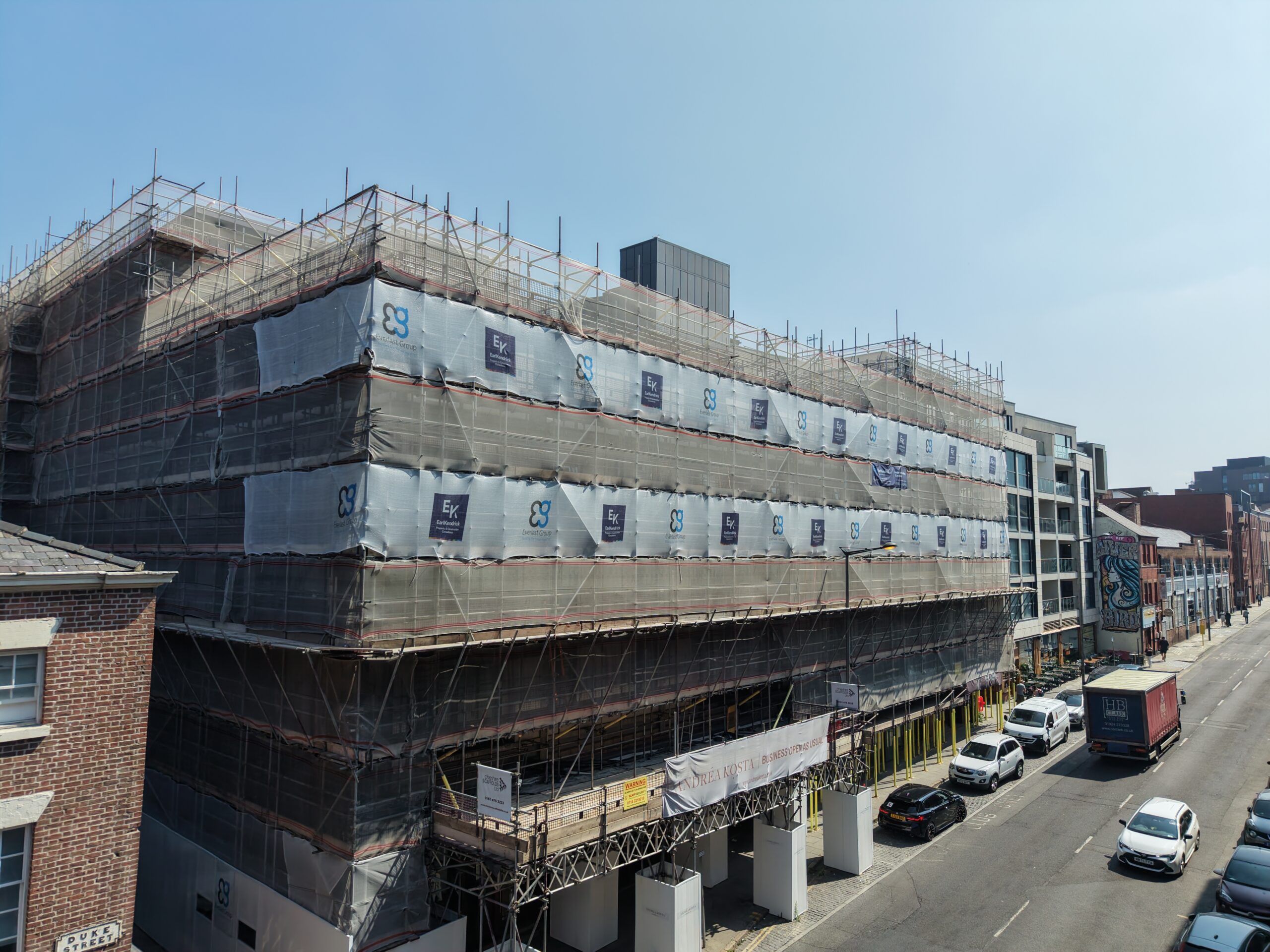 Portside House under construction, covered in scaffolding and branded protective sheeting.